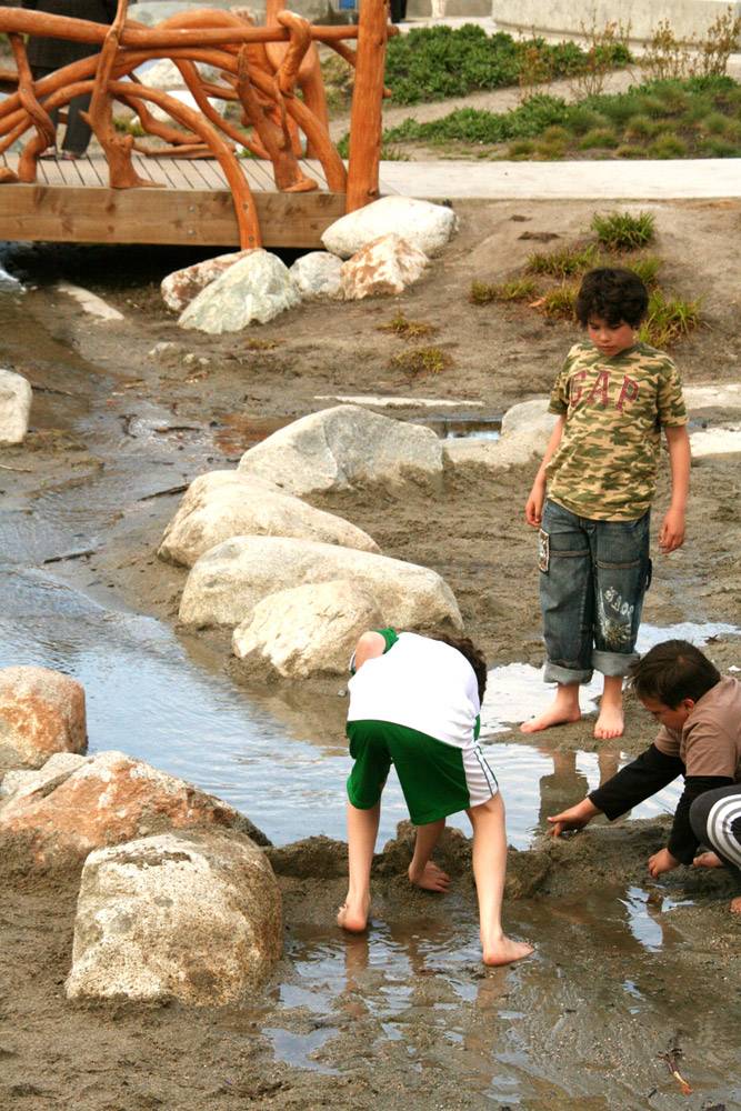 Boulders form the sides of a water channel at this playground