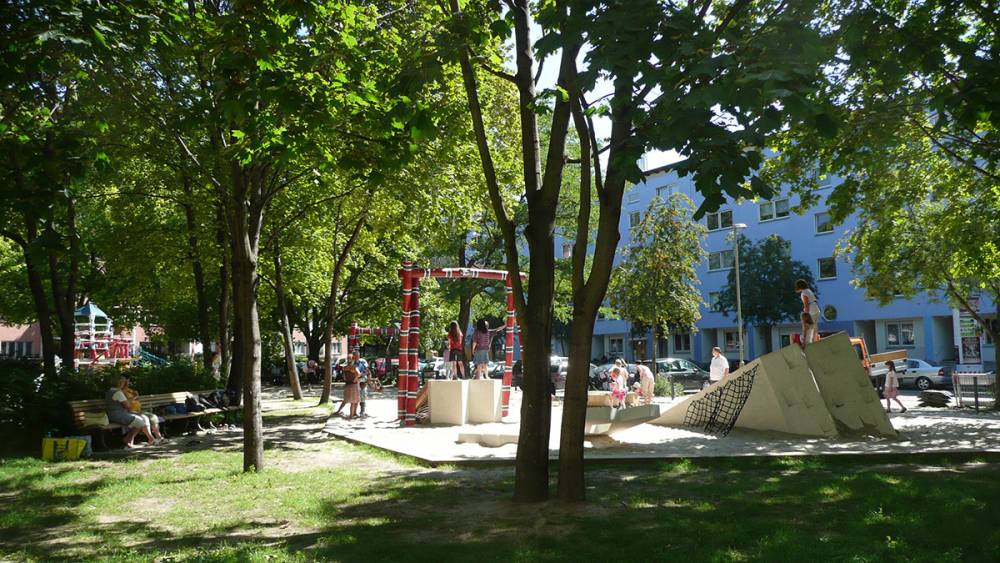 A playground surrounded by shade and soft grass