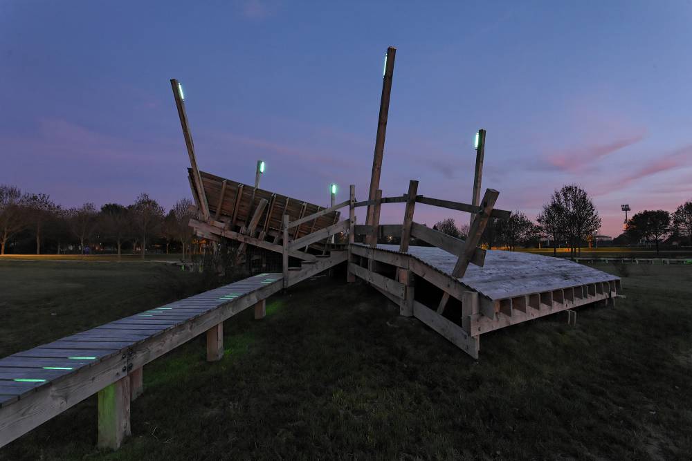 A wooden play structure lit up at night