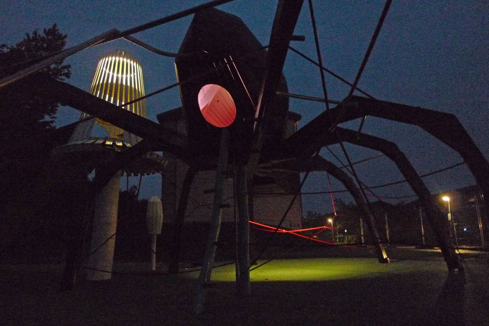 The interior of a spider play structure lit up at night