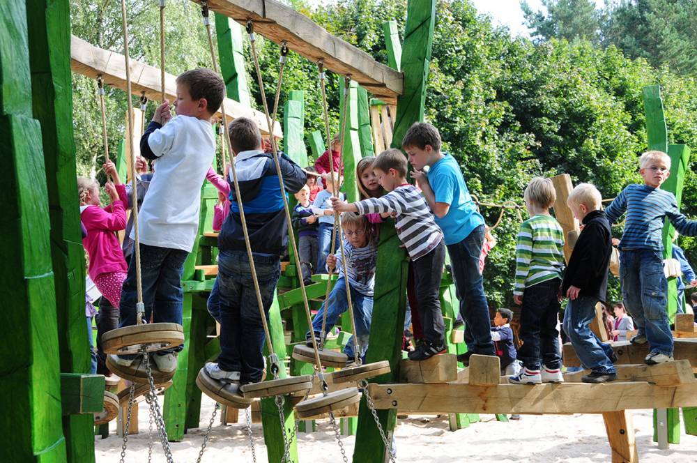 Wood discs provide a place to stand as children cross wobbly ropes