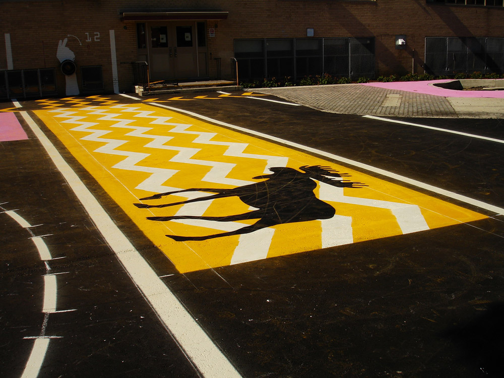 Student entrance with painted asphalt extending onto wall