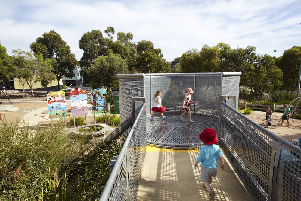 Children running between platforms at this accessible playground