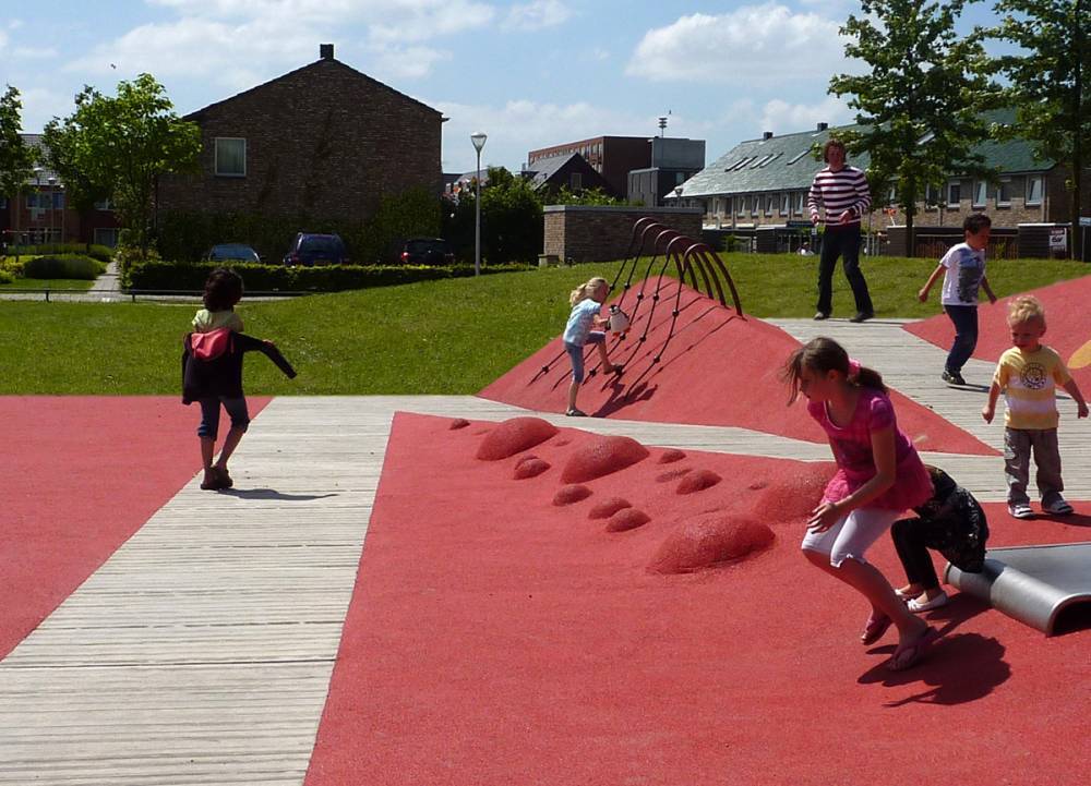 A gently sloping wood ramp is integrated into poured rubber at this accessible play area