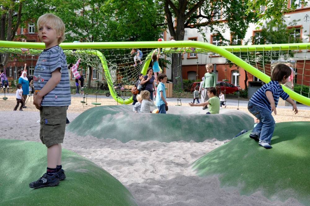 Green rubber mounds in the sand make for a fun play element