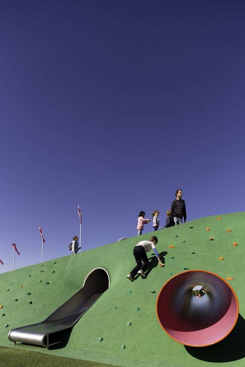 Poured rubber topography with an embedded slide and crawl tube