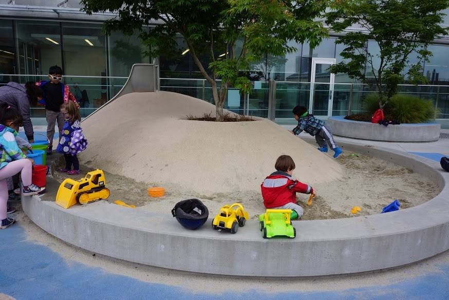 Poured rubber mound that doubles as a planter for a shade tree