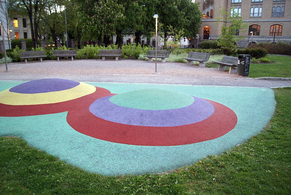 Rubber mounds in a park flanked by museums and a university