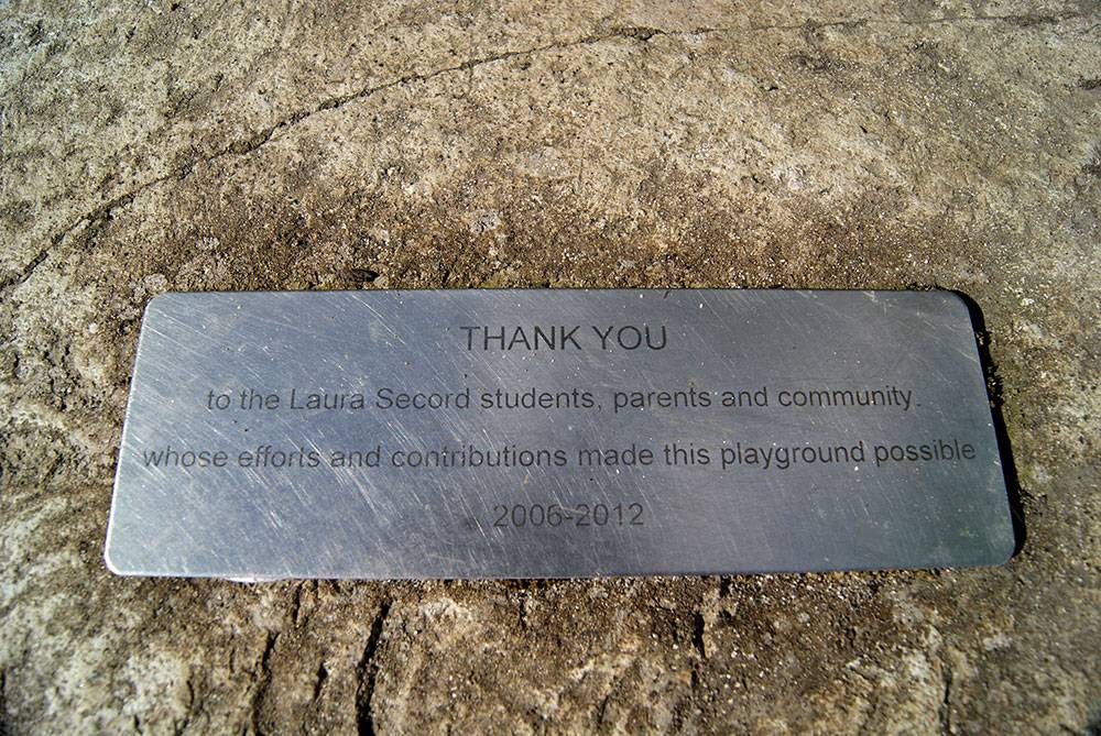 Small plaque on a boulder showing appreciation for contributors