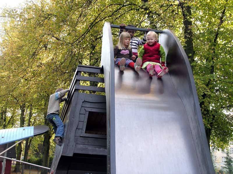 Two friends get ready to tackle the wide slide together