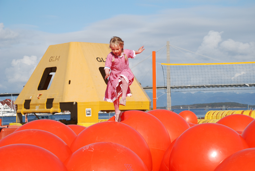 Girl playing on recycled buoys