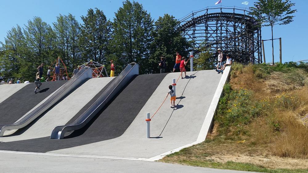 Climbing up a steep poured rubber slope with embedded slides