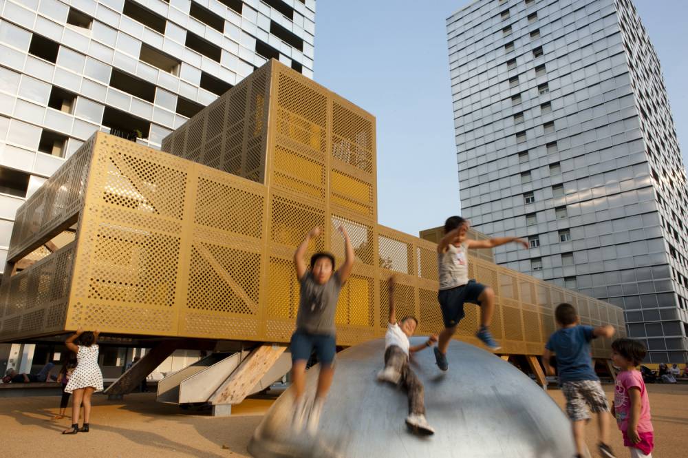 Kids play on the metal dome beside the main play structure