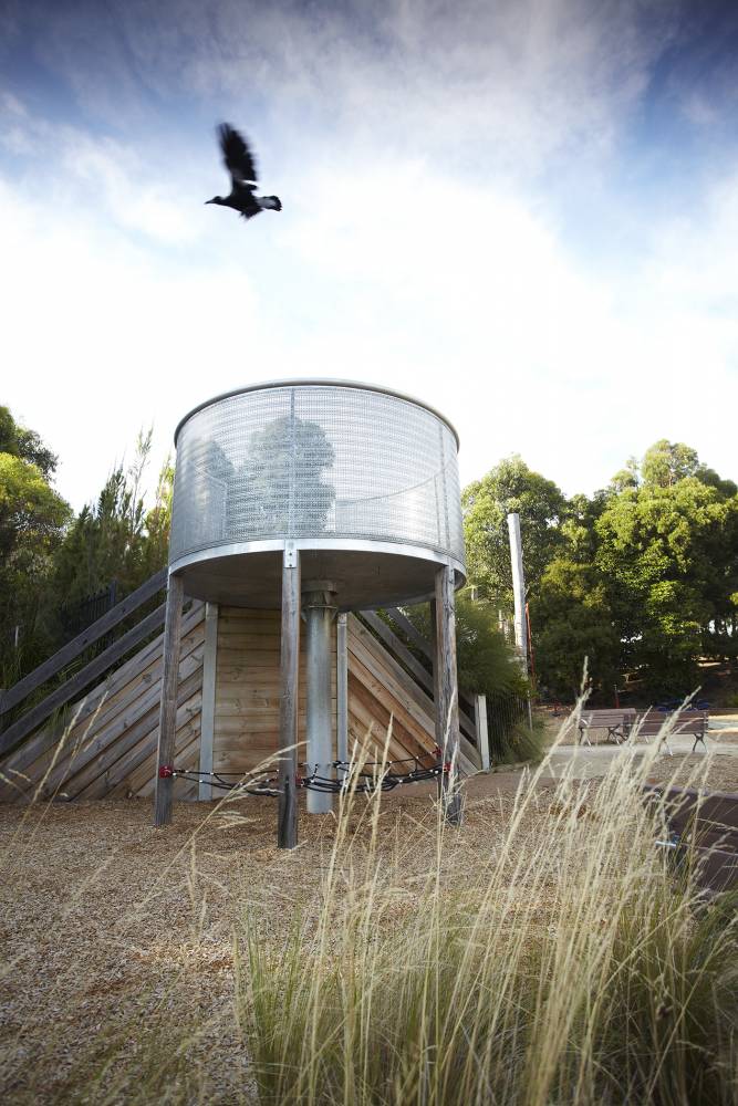 A small climbing net hangs under a lookout tower